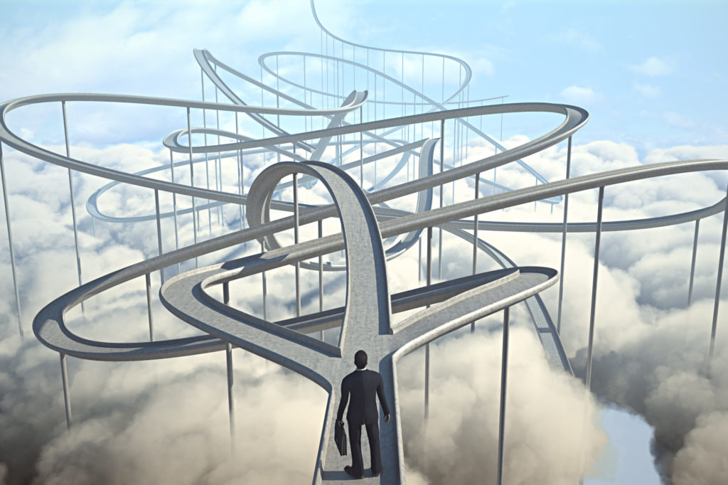businessman looks ahead at winding paths