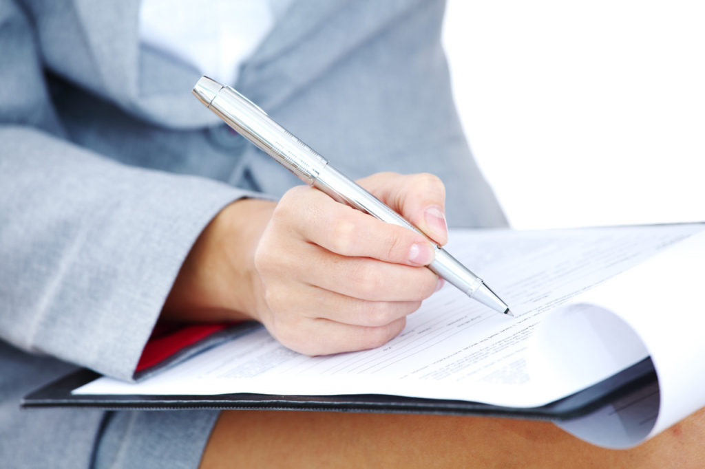 professional fills out form by hand
