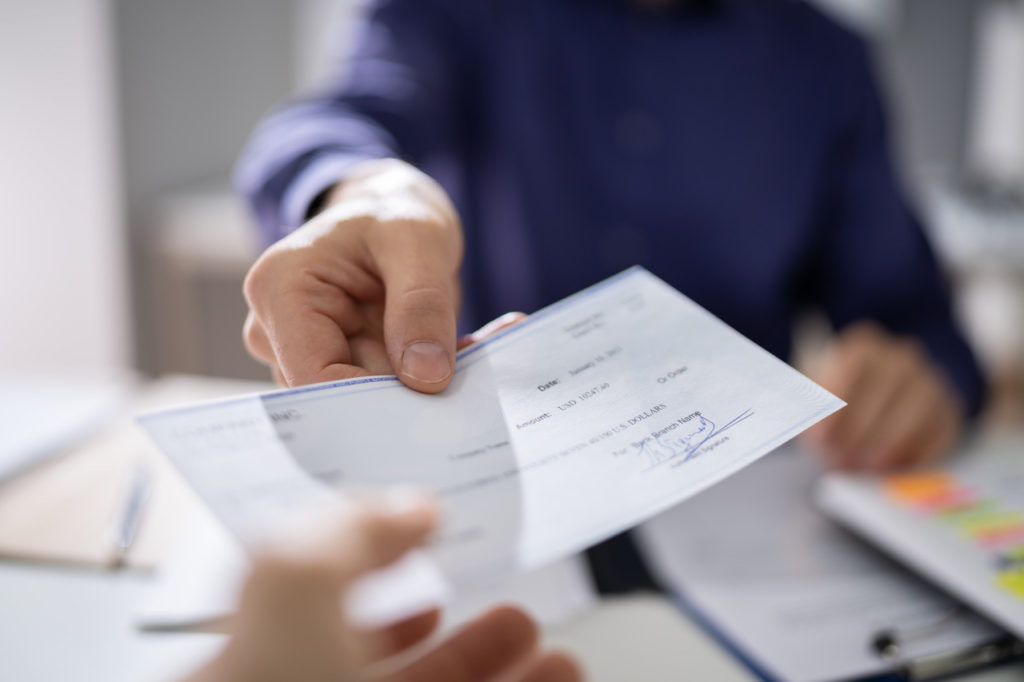 one person hands a paycheck to another